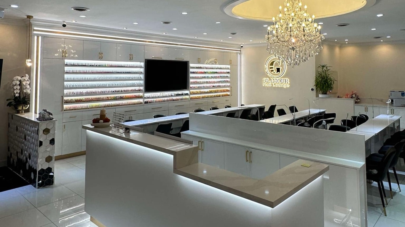 Glamour Nail Lounge luxury salon interior with crystal chandeliers, marble counters, and gold accents